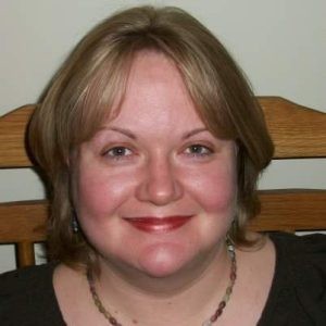 A woman with short blond hair wearing a black shirt.