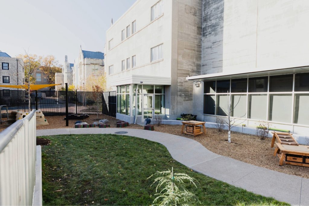 A grassy outdoor classroom with a walking path and areas for children to climb, explore, and discover at the Child Development Lab.