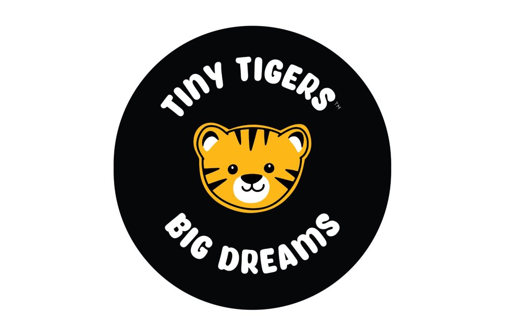 A trademarked logo with a black circle and a cartoon style tiger cub with the Tiny Tigers (above) and Big Dreams (below)