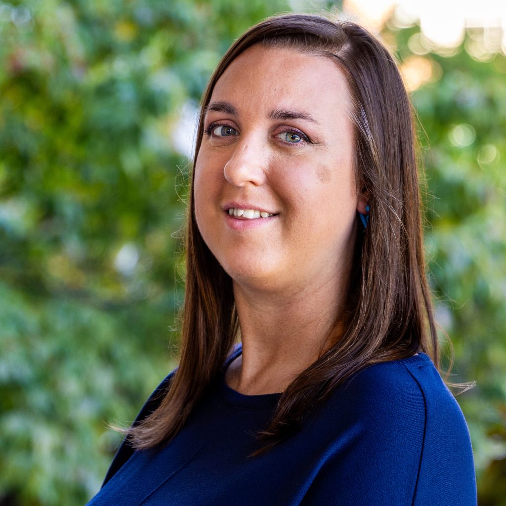 A woman with brown hair and a blue sweater.